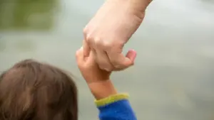 Mutter hält Kind an der Hand