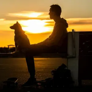 Ein Mann sitzt während des Sonnenuntergangs auf einer Bank