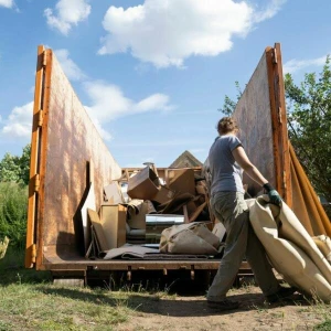 Jemand entsort seinen Sperrmüll in einem Container