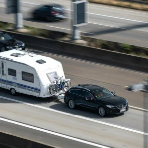 Ein Auto mit einem Wohnwagen fährt auf der Autobahn