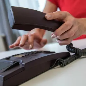 Eine Frau benutzt ein Festnetztelefon