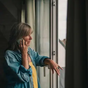 Eine Frau telefoniert am Fenster