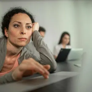 Frau sitzt gelangweilt am Laptop