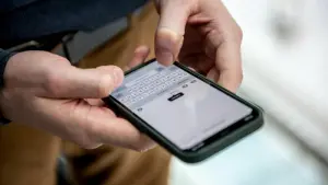 Ein Mann tippt eine Nachricht auf einem iPhone 12