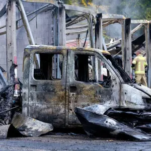 Lagerhalle mit Feuerwehrfahrzeugen bei Brand zerstört
