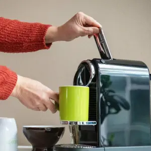 Eine Person bedient eine Kaffeemaschine