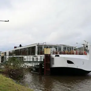 Flusskreuzfahrtschiff auf Main fährt gegen Eisenbahnbrücke