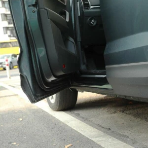 Auto parkt mit offener Autotür am Straßenrand