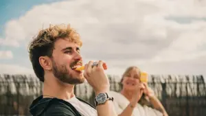 Ein junger Mann isst ein Wassereis am Stiel