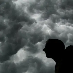 Ein Mann steht unter einem stürmischen Himmel