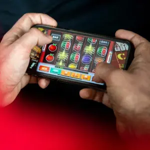 Ein Mann spielt am Smartphone ein Glücksspiel