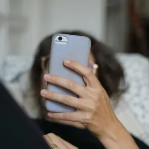Eine Frau scrollt auf ihrem Smartphone