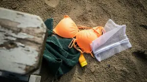 Waschnetz und Badeutensilien liegen im Sand