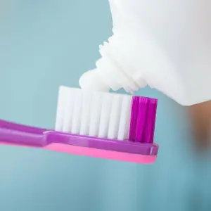 Zahnpasta wird auf eine Bürste aufgetragen