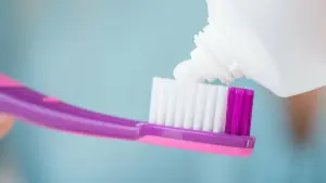 Zahnpasta wird auf eine Bürste aufgetragen
