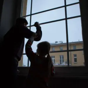Erwachsener und Kind stehen an einem Fenster