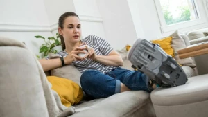 Eine Frau liegt mit einer Orthese auf dem Sofa