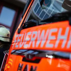 Feuerwehrmann steht neben einem Feuerwehrauto (Symbolbild)