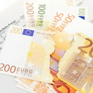 Ein zerissener 200-Euro-Schein liegt auf einer Gehaltsabrechnung