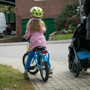 Ein Kind fährt auf dem Gehweg Fahrrad