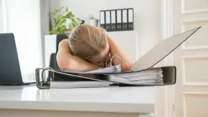 Eine Frau schläft am Schreibtisch