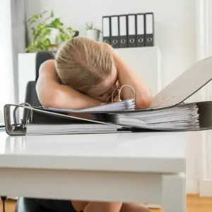 Eine Frau schläft am Schreibtisch