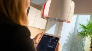 Eine Frau regelt die Küchenbeleuchtung mit einem Tablet