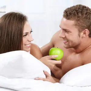 Paar im Bett mit Apfel