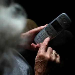 Eine Frau wählt eine Nummer auf einem Telefon