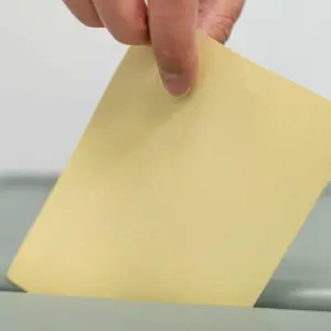 Ein Mann wirft einen Stimmzettel in eine Wahlurne