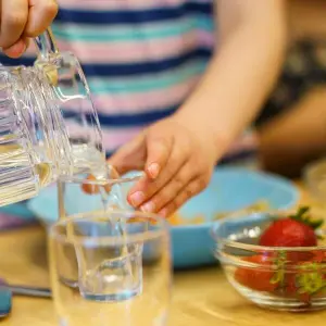 Ein Kita-Kind schenkt sich Wasser ein