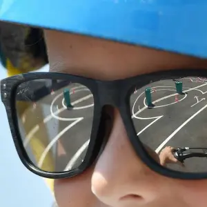 Ein Junge trägt eine Sonnenbrille auf einem Fahrrad-Parcours