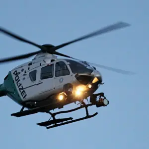 Ein Polizeihubschrauber mit eingeschalteten Scheinwerfern