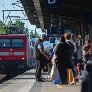 Reisende an einem Bahnhof