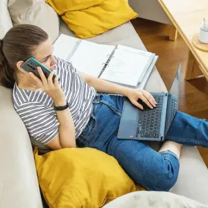 Eine Frau am Telefon und Laptop