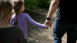 Ein Mann hält seine Tochter an der Hand