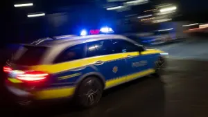 Ein Polizeiauto fährt mit Blaulicht zum Einsatz.