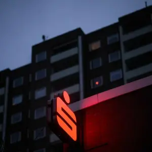 Ein Logo der Sparkasse leuchtet an einer Filiale