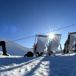 Skifahrer pausieren in Liegestühlen