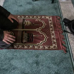 Muslim betet auf Gebetsteppich in Moschee