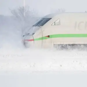 Ein ICE fährt durch eine Winterlandschaft