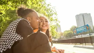 Ein junges Paar lacht verliebt in einem Park