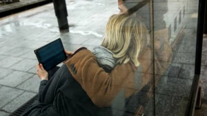 Ein Paar sieht auf ein Tablet am Bahnhof