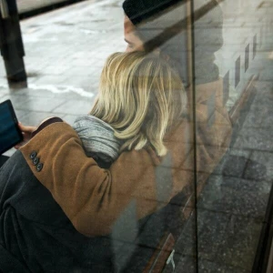 Ein Paar sieht auf ein Tablet am Bahnhof