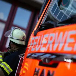 Feuerwehrmann steht neben einem Feuerwehrauto.