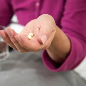 Frau mit Tabletten in der Hand