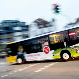 Ein Linienbus fährt am Morgen über eine Kreuzung