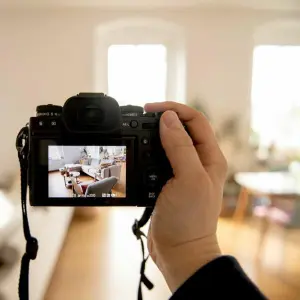 Ein Mann macht Fotoaufnahmen in einer Wohnung