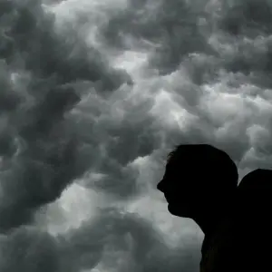 Ein Mann steht unter einem stürmischen Himmel