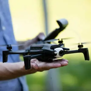 Ein Mann hält eine Drohne in der Hand
